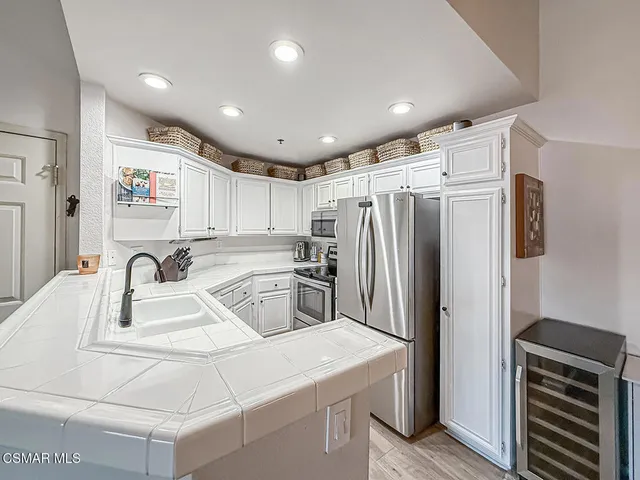 a kitchen with kitchen island a refrigerator sink and stove