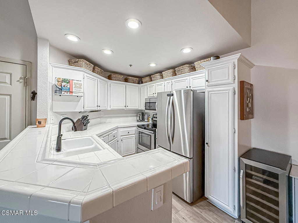 5837 Oak Bend Lane, Unit 302 Oak Park, CA 91377 - Photo 11 of 59 a kitchen with kitchen island a refrigerator sink and stove