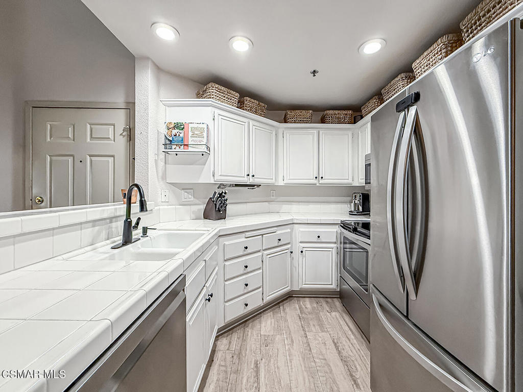 5837 Oak Bend Lane, Unit 302 Oak Park, CA 91377 - Photo 12 of 59 a kitchen with stainless steel appliances cabinets a sink and a large window