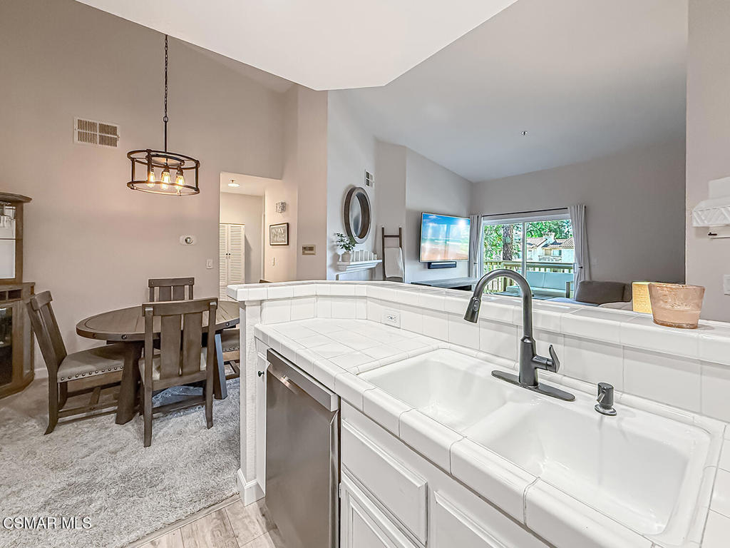 5837 Oak Bend Lane, Unit 302 Oak Park, CA 91377 - Photo 14 of 59 a kitchen with a sink and chairs