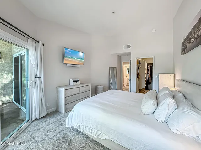 a bedroom with a bed and a painting on the wall