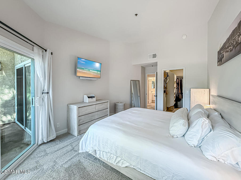 5837 Oak Bend Lane, Unit 302 Oak Park, CA 91377 - Photo 19 of 59 a bedroom with a bed and a painting on the wall