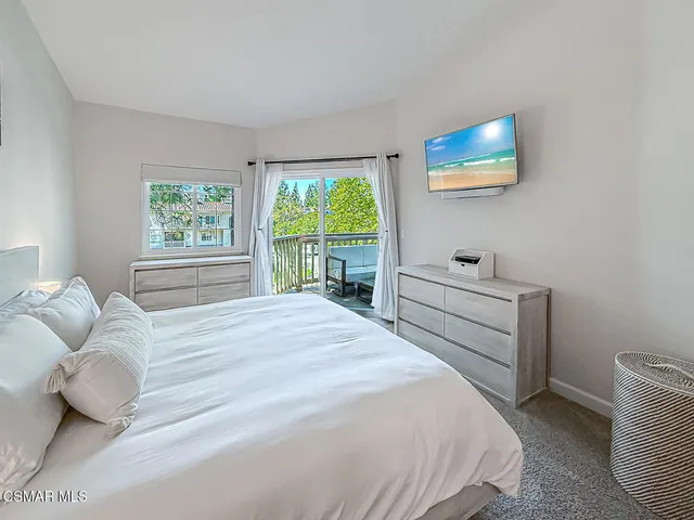 a bedroom with a bed and a large window