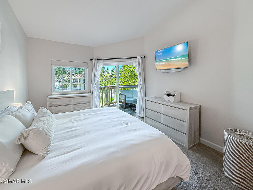 5837 Oak Bend Lane, Unit 302 Oak Park, CA 91377 - Photo 20 of 59 a bedroom with a bed and a large window