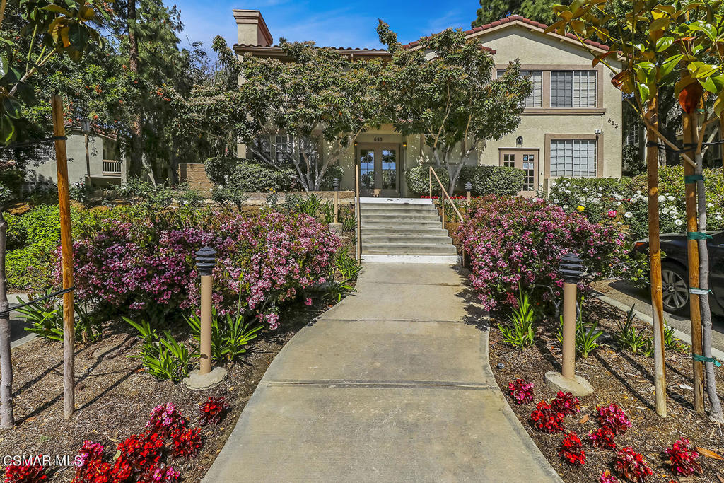 5837 Oak Bend Lane, Unit 302 Oak Park, CA 91377 - Photo 27 of 59 a front view of a house with a yard and flowers