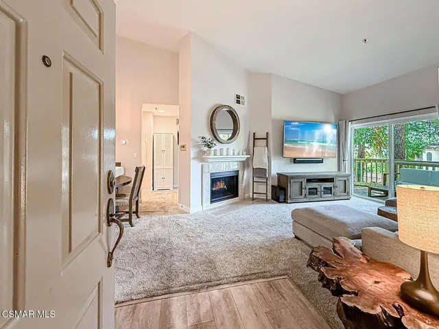 a living room with furniture a fireplace and a large window