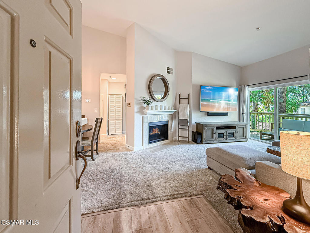 5837 Oak Bend Lane, Unit 302 Oak Park, CA 91377 - Photo 4 of 59 a living room with furniture a fireplace and a large window