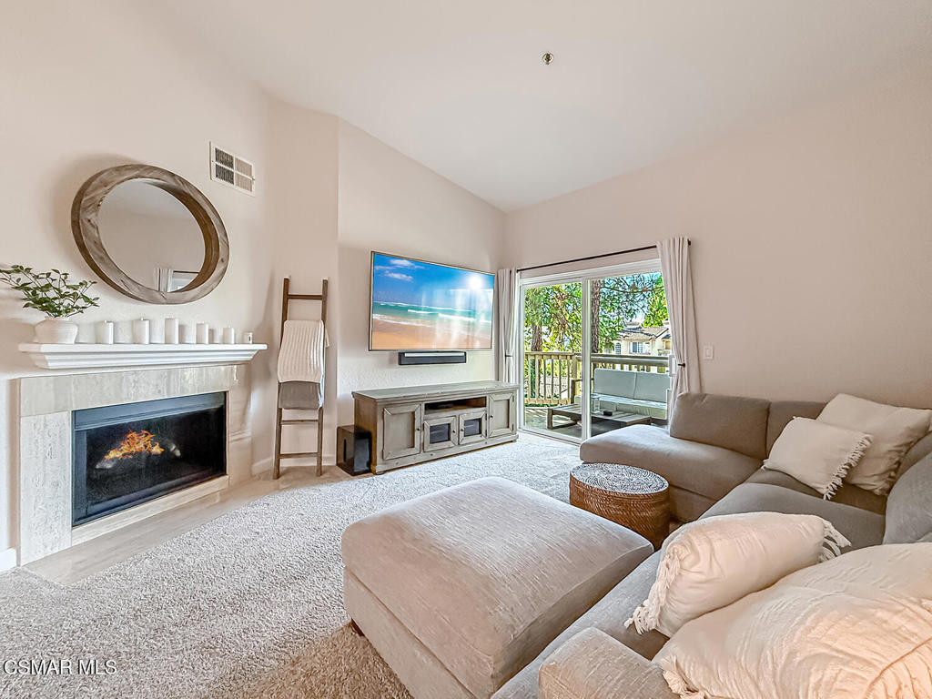 5837 Oak Bend Lane, Unit 302 Oak Park, CA 91377 - Photo 6 of 59 a living room with furniture a fireplace a flat screen tv and a large window