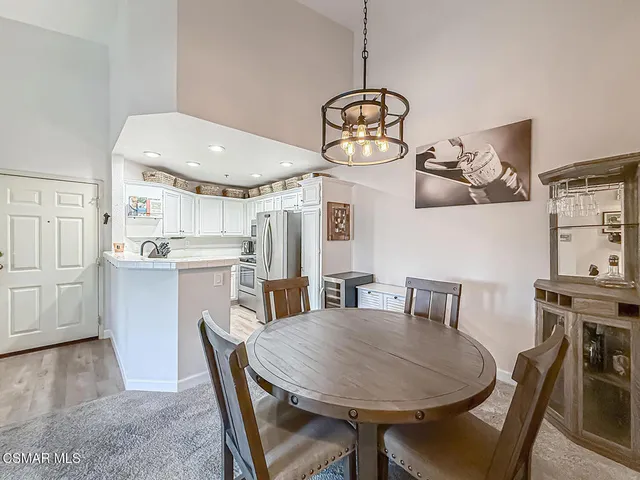 a view of a dining room with furniture a chandelier and wooden floor