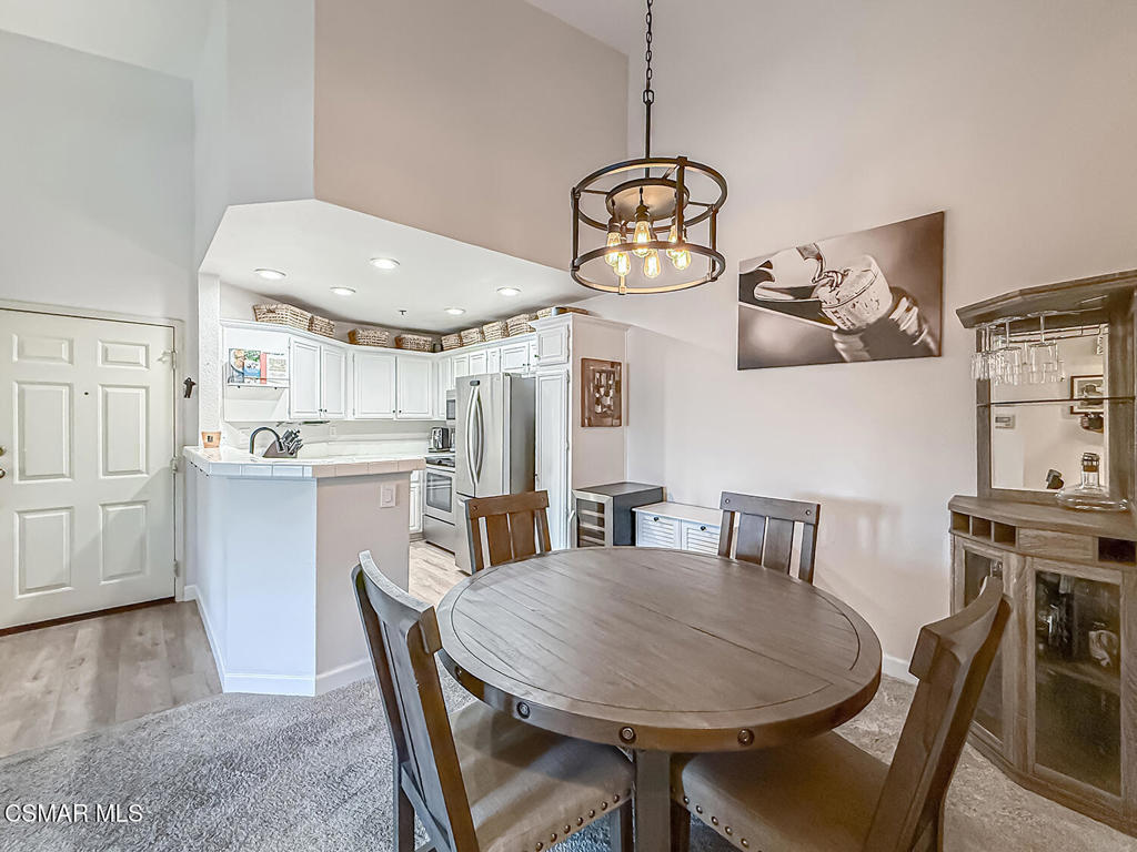 5837 Oak Bend Lane, Unit 302 Oak Park, CA 91377 - Photo 9 of 59 a view of a dining room with furniture a chandelier and wooden floor