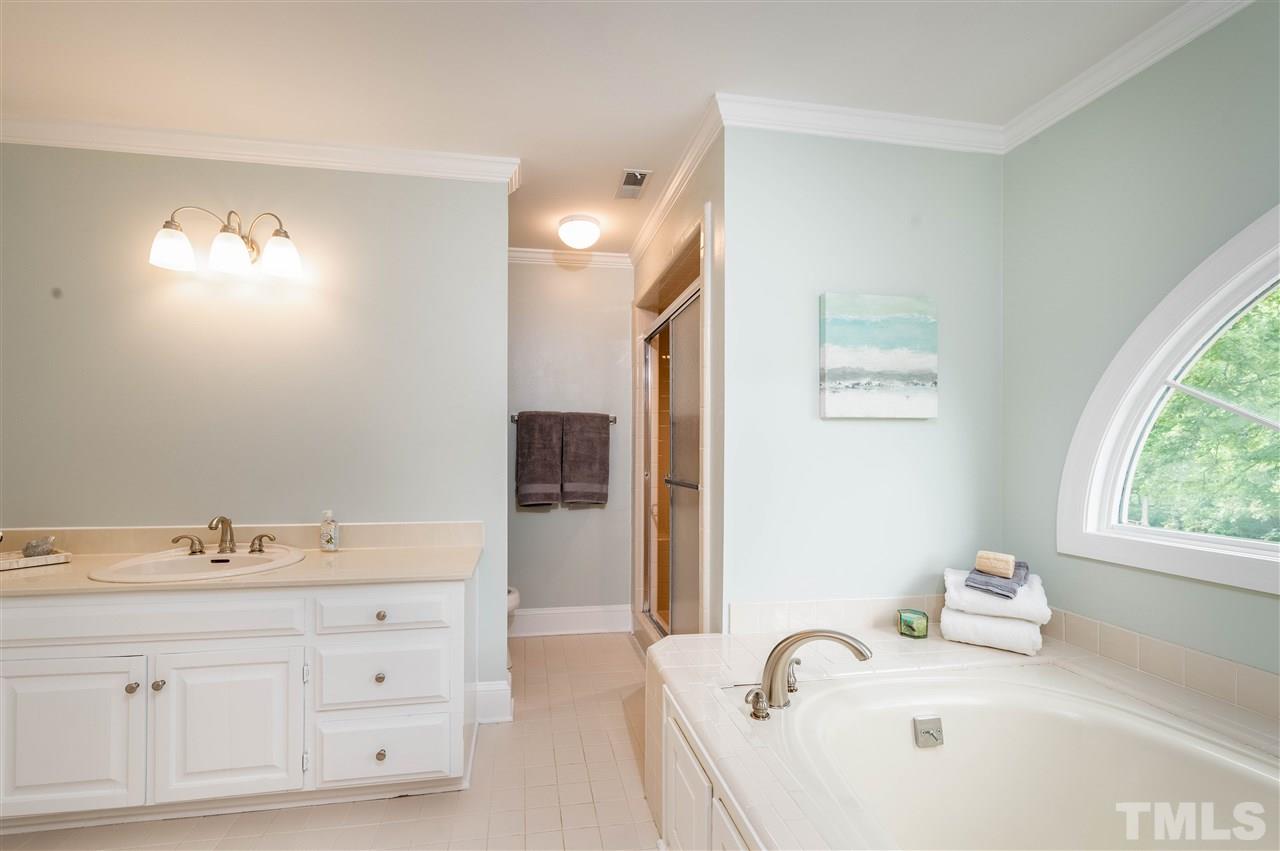 2105 Inverrary Court Raleigh, NC 27615 - Photo 16 of 29 a bathroom with a bathtub sink and mirror