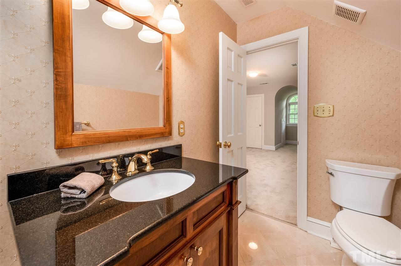 2105 Inverrary Court Raleigh, NC 27615 - Photo 22 of 29 a bathroom with a granite countertop sink a toilet a mirror and shower