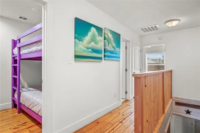 a view of a hallway with wooden floor and windows