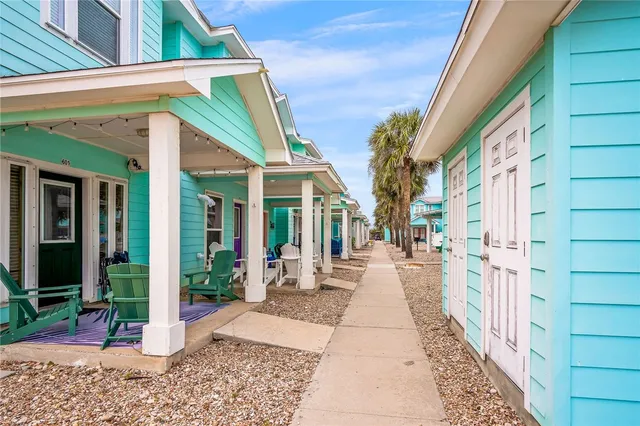 a view of a patio with a couple of cars parked in front of house