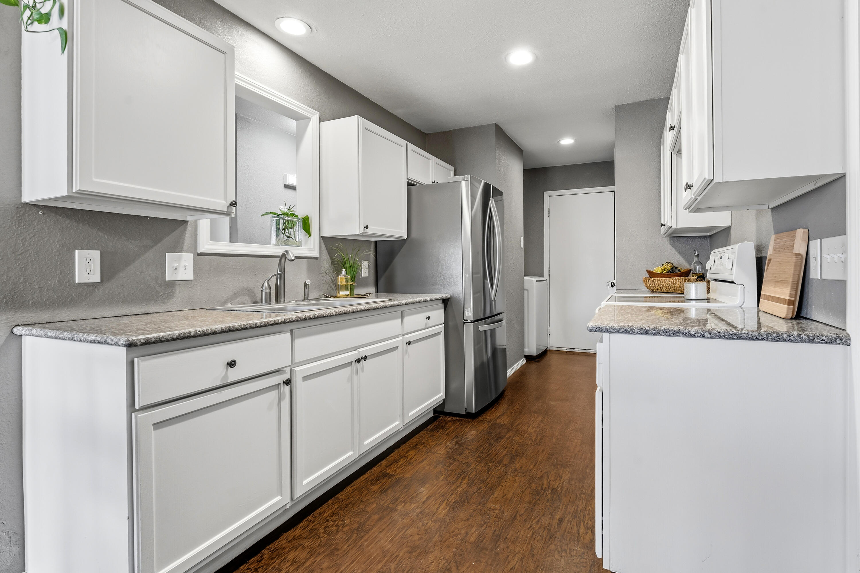 5736 2nd Place Lubbock, TX 79416 - Photo 11 of 26 a kitchen with stainless steel appliances granite countertop a refrigerator sink and cabinets
