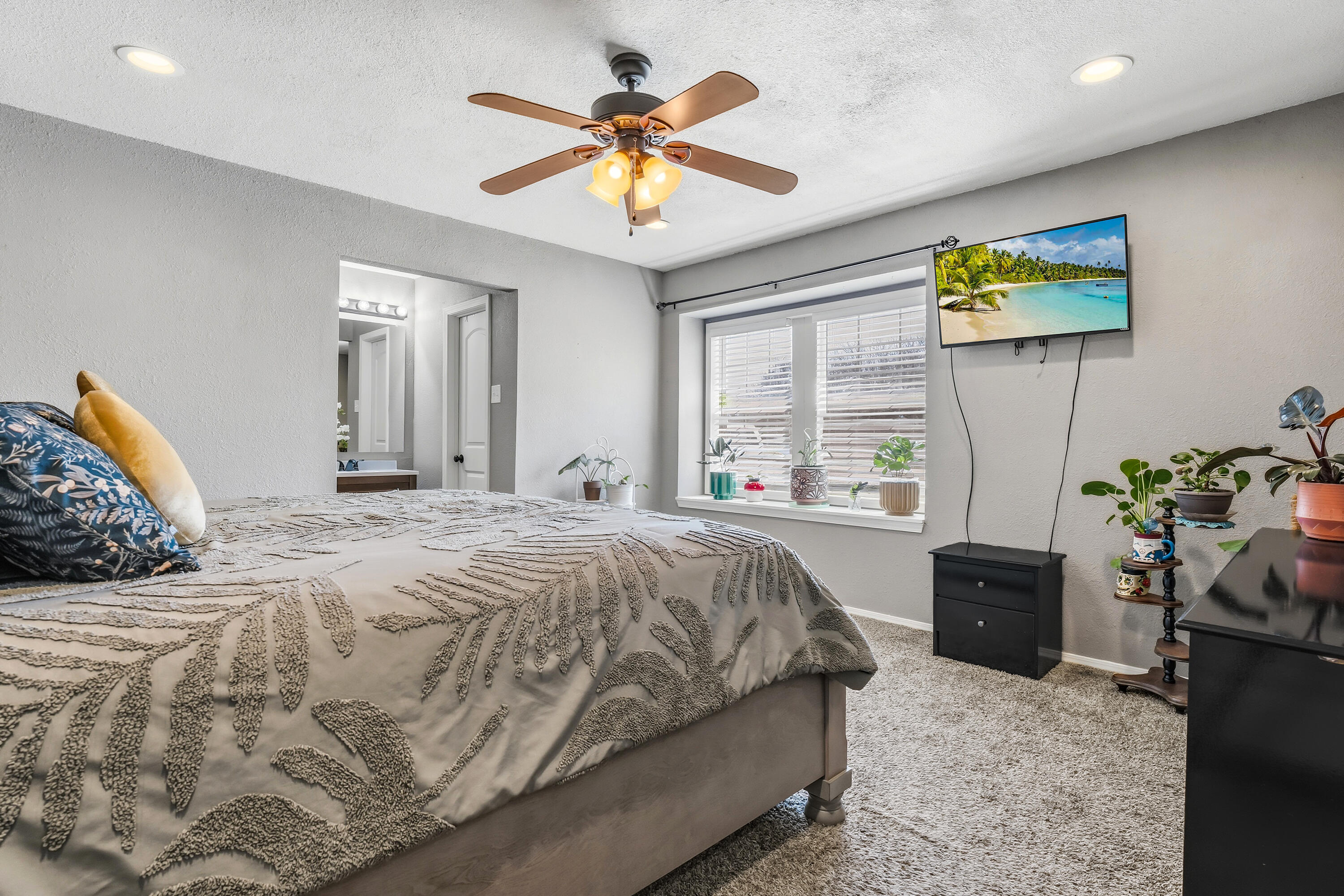 5736 2nd Place Lubbock, TX 79416 - Photo 14 of 26 a bedroom with a bed and a chandelier