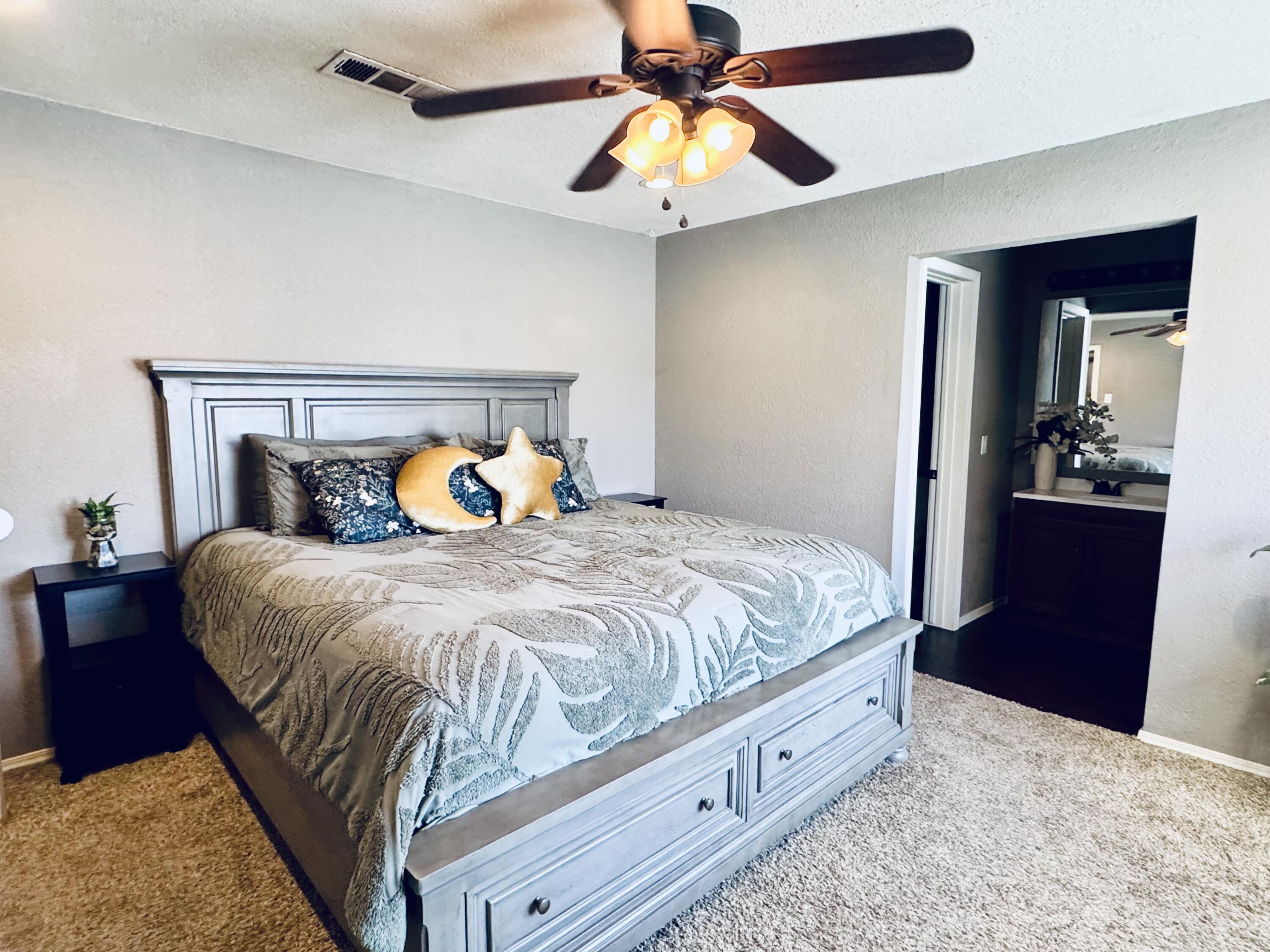 5736 2nd Place Lubbock, TX 79416 - Photo 15 of 26 a bedroom with a bed and a chandelier