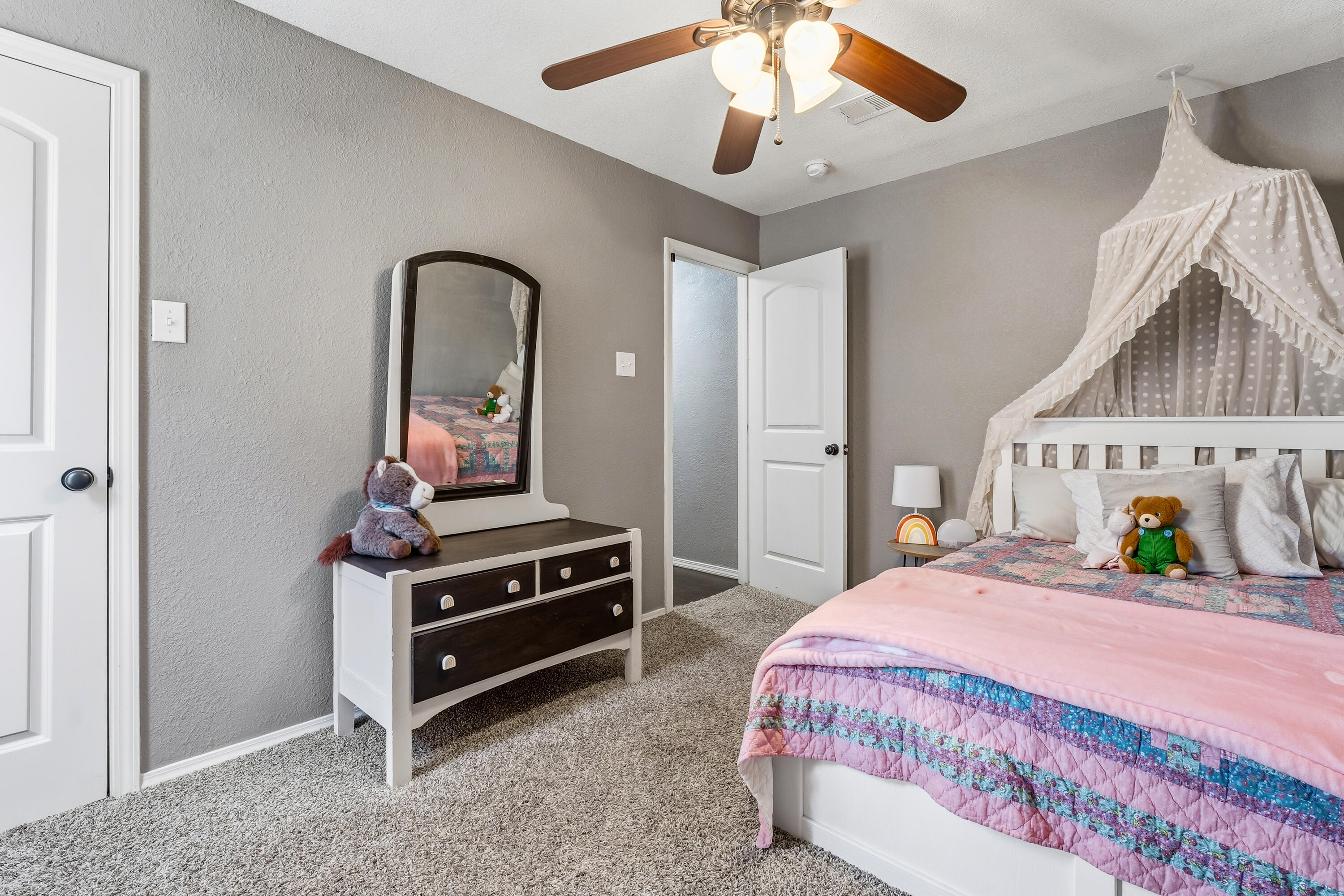 5736 2nd Place Lubbock, TX 79416 - Photo 22 of 26 a bedroom with a bed and a chandelier