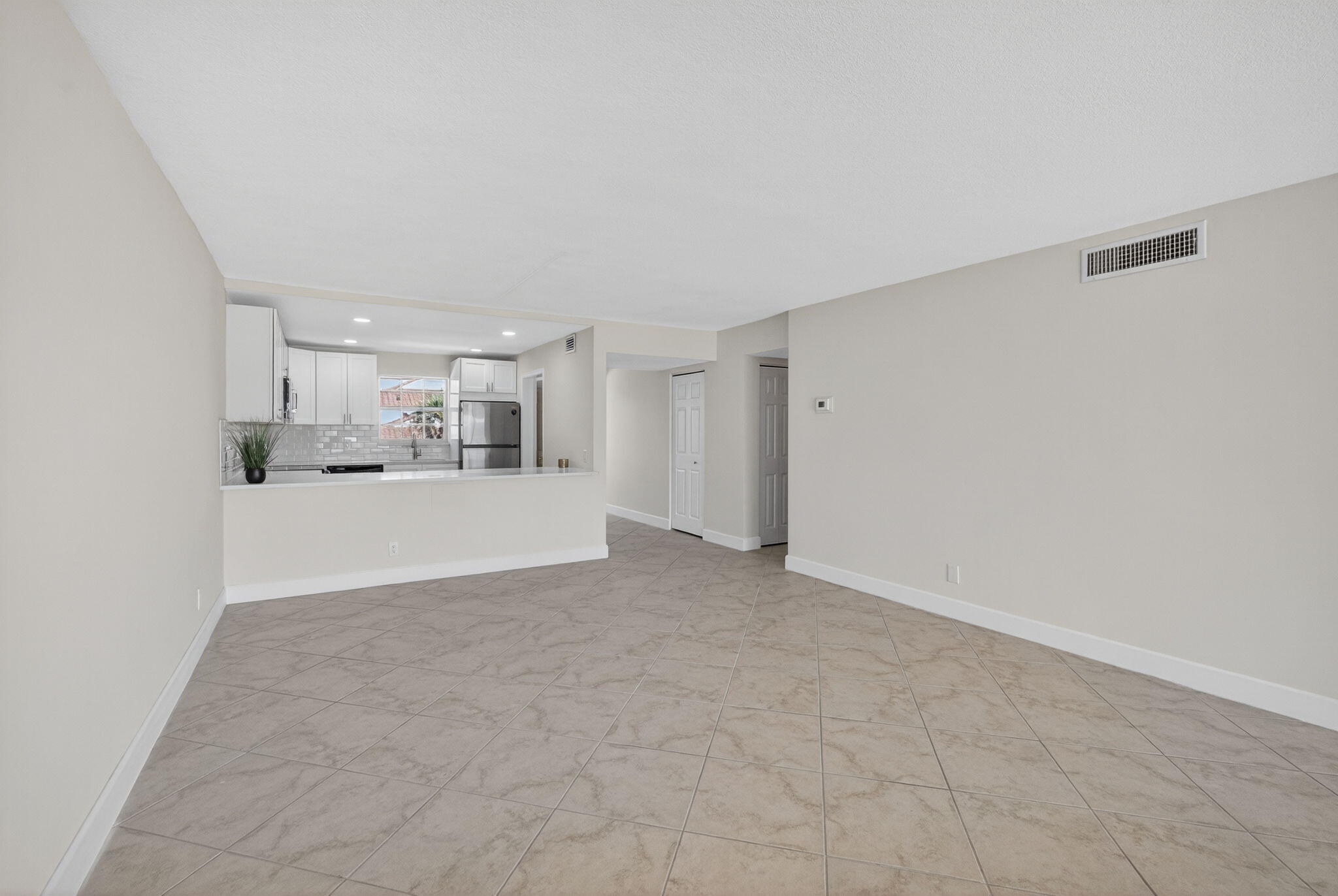 100 Waterway Road, Unit A304 Tequesta, FL 33469 - Photo 13 of 90 a view of a kitchen with white cabinets and a refrigerator