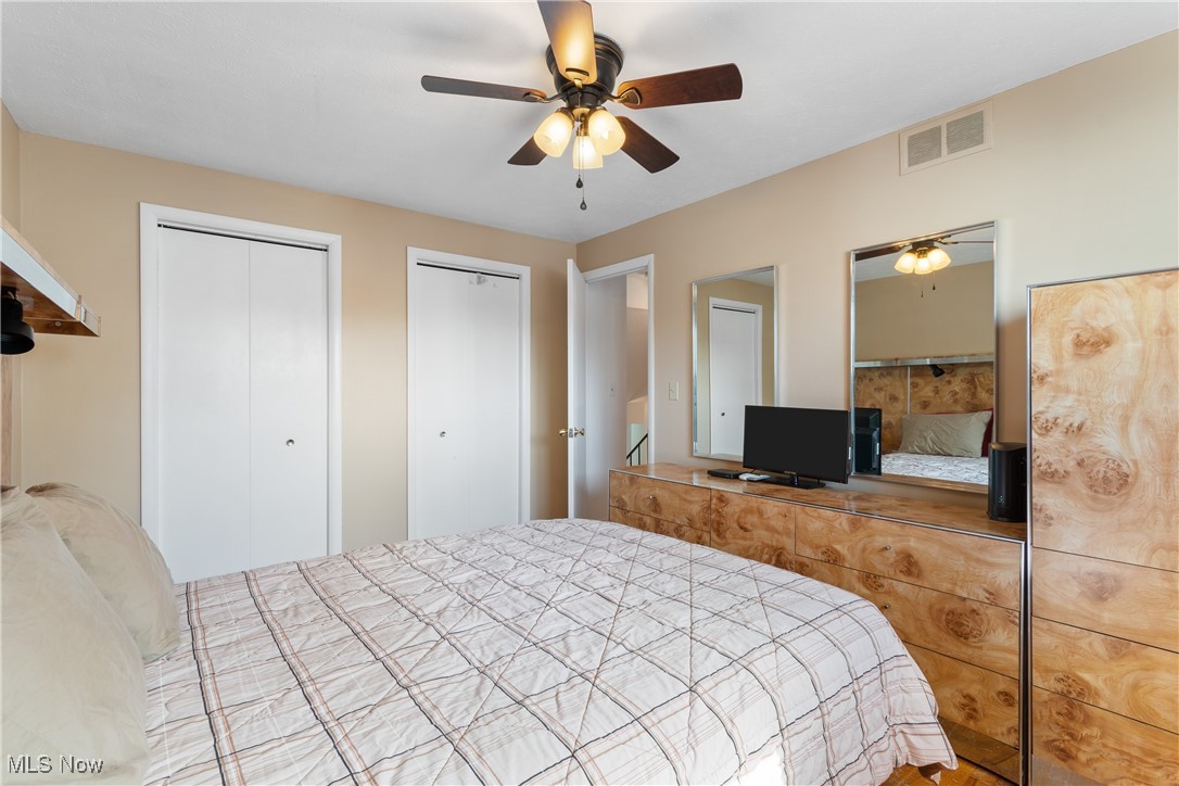 447 Center Road Bedford, OH 44146 - Photo 15 of 33 Bedroom with a ceiling fan, visible vents, and multiple closets