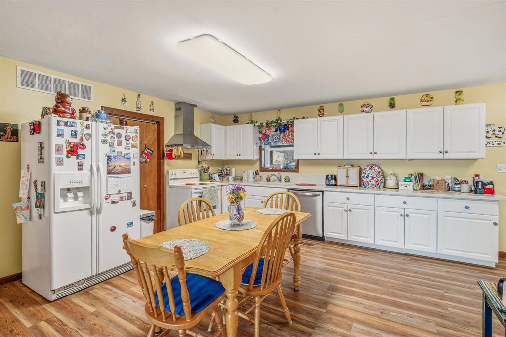 941 Farm To Market 1287 Graham, TX 76450 - Photo 4 of 39 a kitchen with stainless steel appliances granite countertop a refrigerator a sink dishwasher and white cabinets with wooden floor