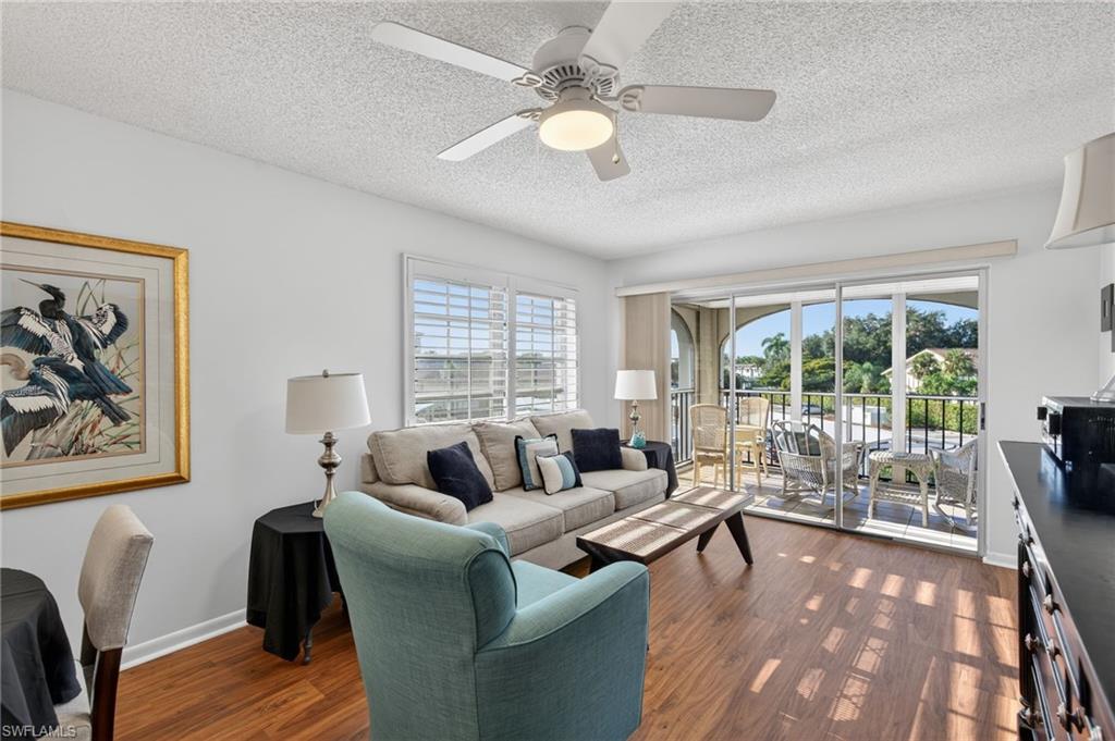 5 High Point Circle West, Unit 303 Naples, FL 34103 - Photo 15 of 36 a living room with furniture and a large window