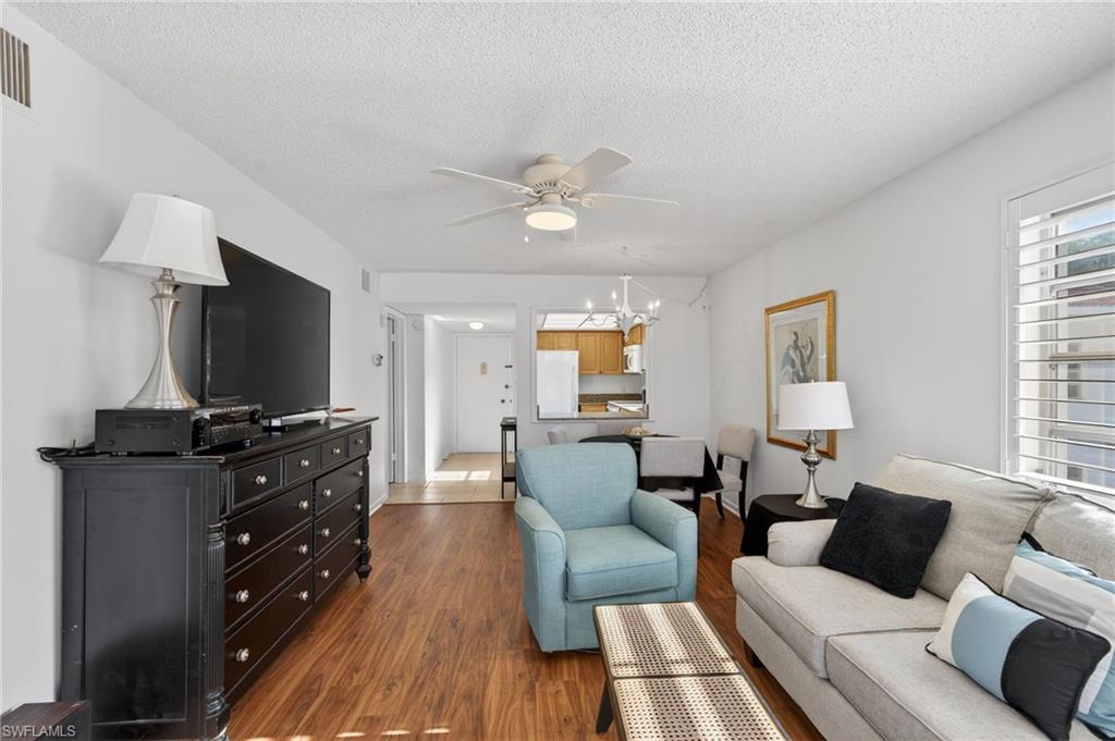 5 High Point Circle West, Unit 303 Naples, FL 34103 - Photo 18 of 36 a living room with furniture and a flat screen tv