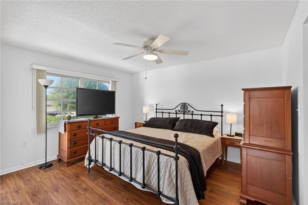 5 High Point Circle West, Unit 303 Naples, FL 34103 - Photo 19 of 36 a bedroom with bed and flat screen tv