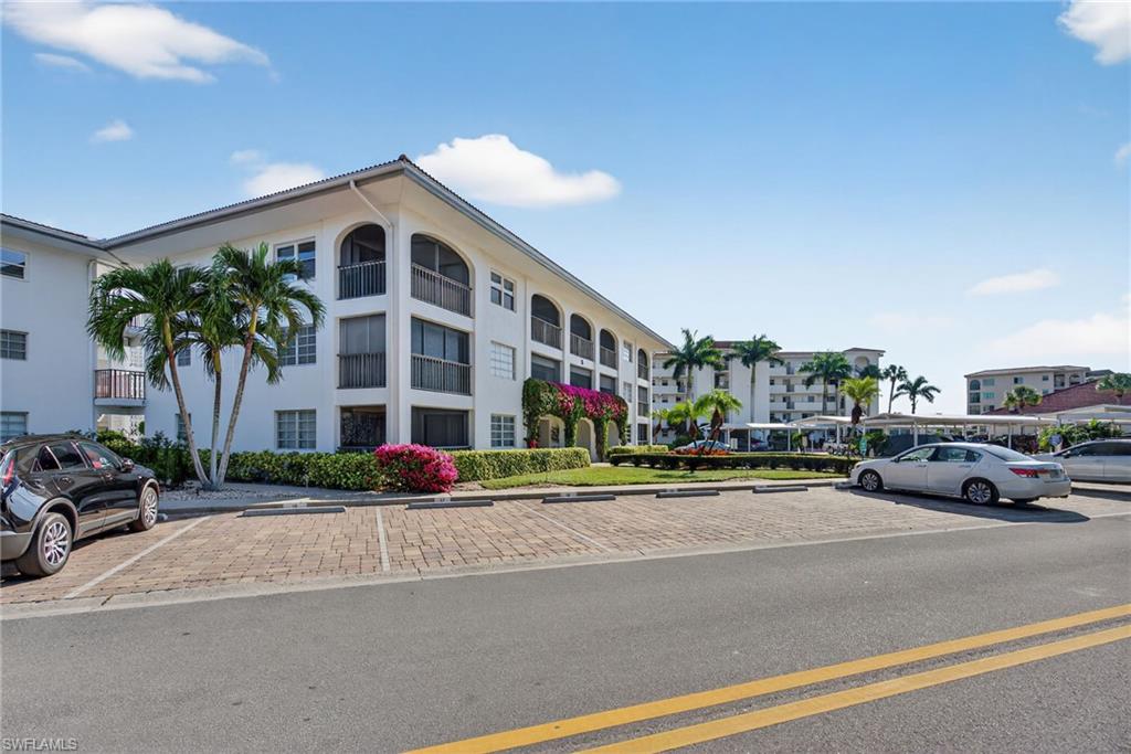 5 High Point Circle West, Unit 303 Naples, FL 34103 - Photo 2 of 36 a cars parked in front of a building