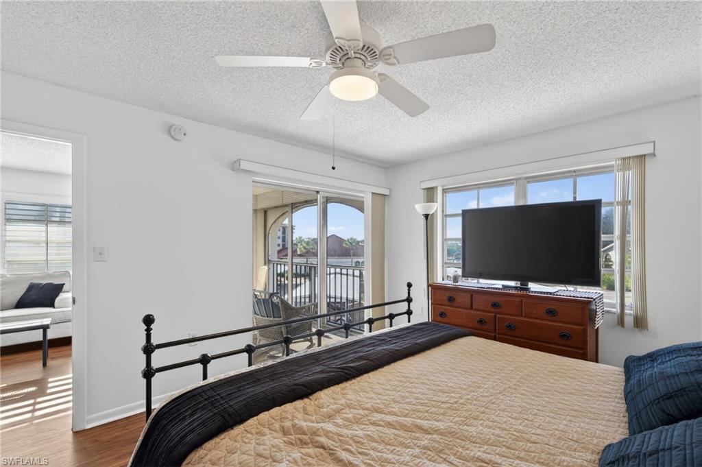 5 High Point Circle West, Unit 303 Naples, FL 34103 - Photo 21 of 36 a bedroom with a bed and a flat screen tv