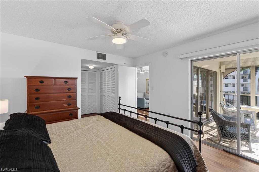 5 High Point Circle West, Unit 303 Naples, FL 34103 - Photo 22 of 36 a bedroom with a bed and a chandelier