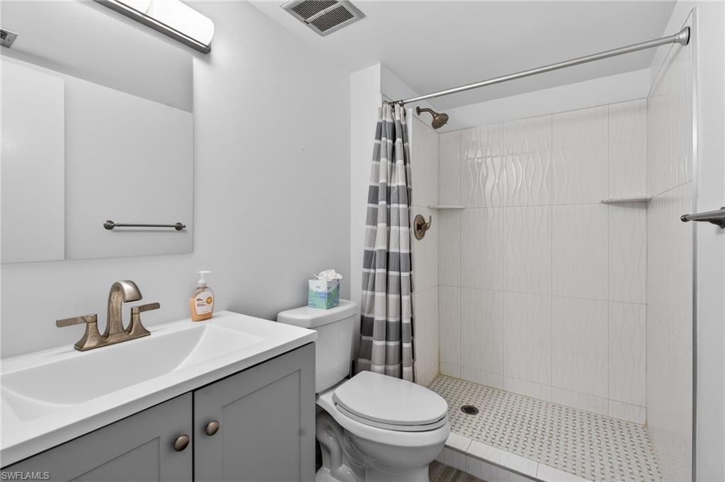 5 High Point Circle West, Unit 303 Naples, FL 34103 - Photo 27 of 36 a bathroom with a sink toilet and shower