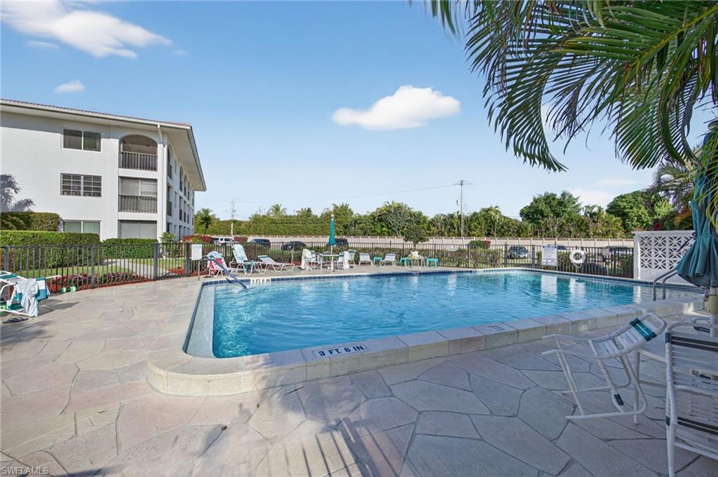 5 High Point Circle West, Unit 303 Naples, FL 34103 - Photo 30 of 36 a view of swimming pool with outdoor seating and plants