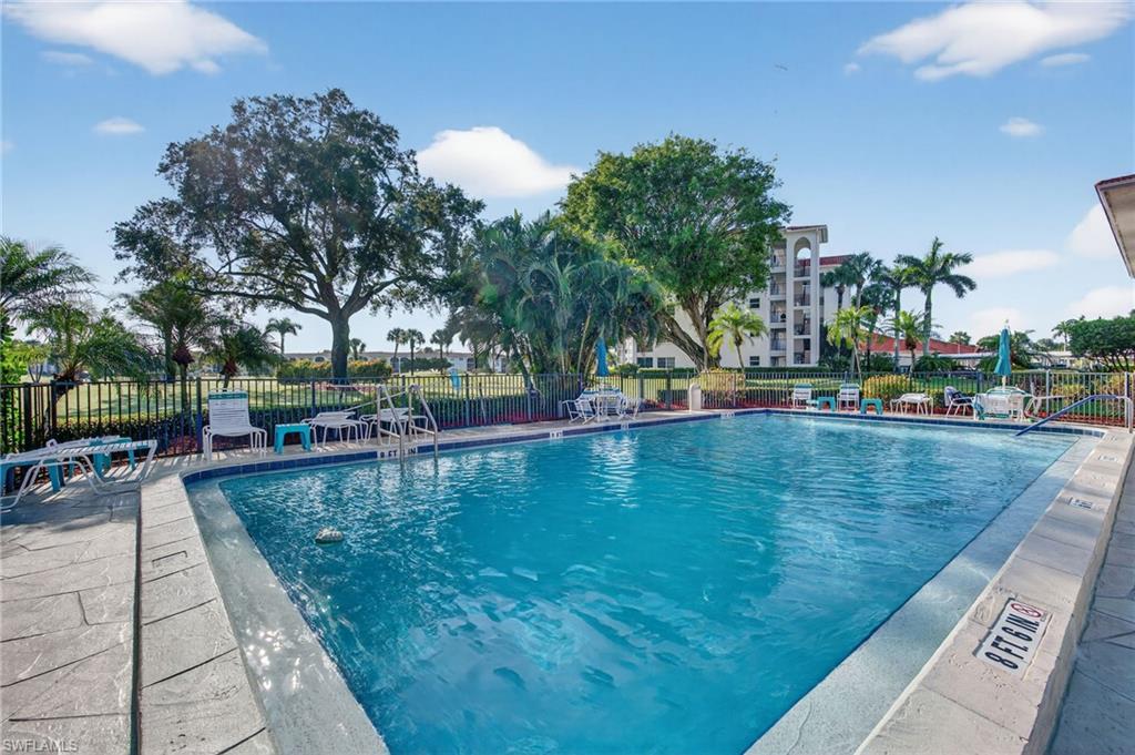 5 High Point Circle West, Unit 303 Naples, FL 34103 - Photo 32 of 36 a view of swimming pool with outdoor seating and plants