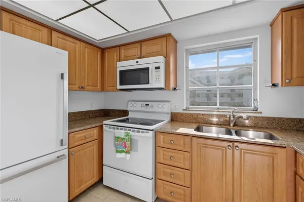 a kitchen with stainless steel appliances granite countertop a sink stove and microwave