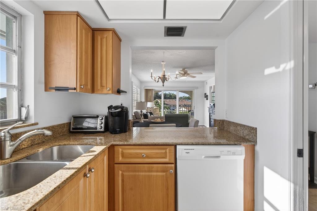 5 High Point Circle West, Unit 303 Naples, FL 34103 - Photo 36 of 36 a kitchen with a sink a counter top space cabinets and a window