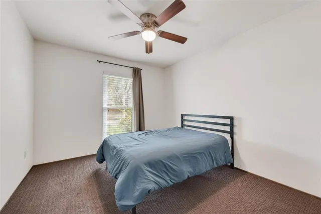 a bedroom with a bed and a ceiling fan