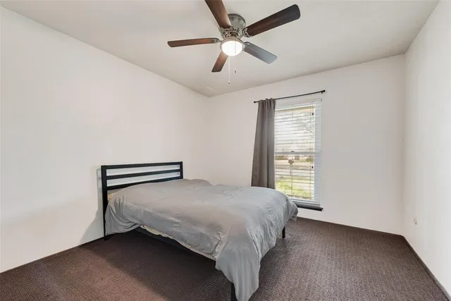 a bedroom with a bed and a ceiling fan