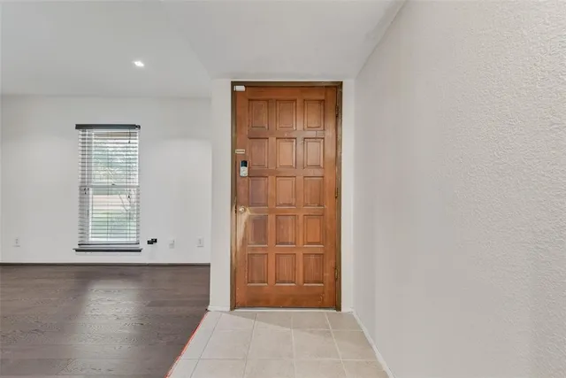 an empty room with wooden floor cabinet and windows