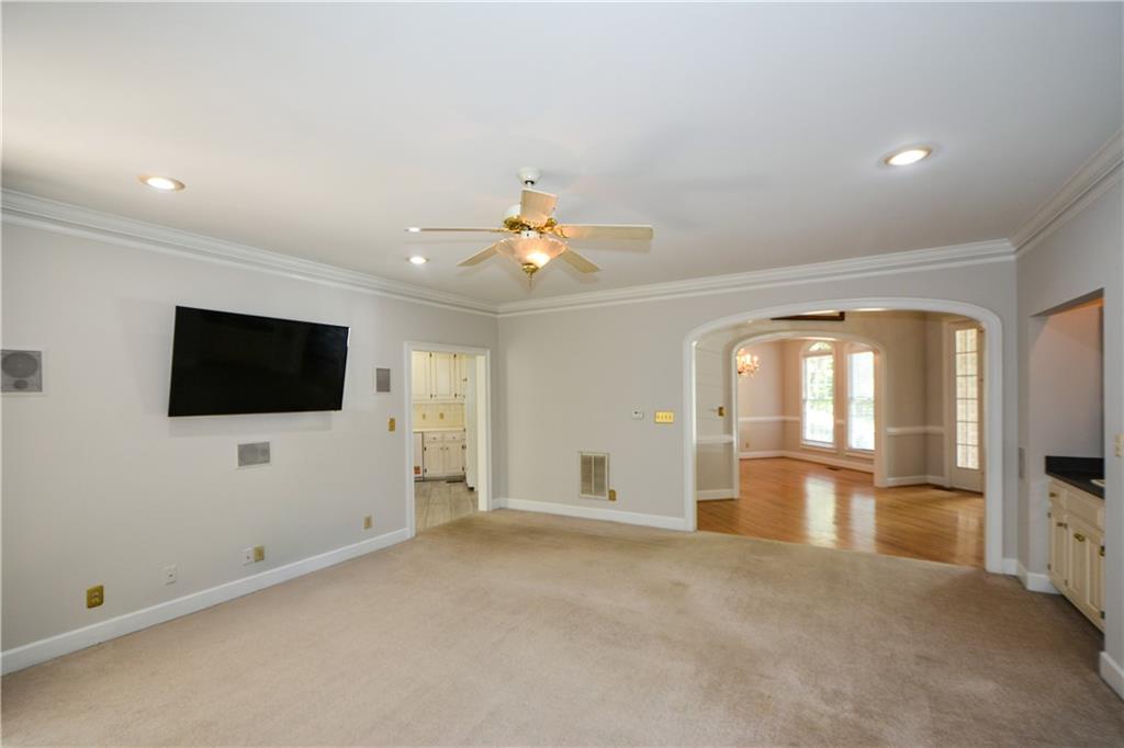 40 Waverly Lane Winder, GA 30680 - Photo 9 of 40 an empty room with a flat screen tv and a kitchen