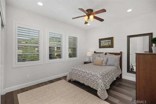 a bedroom with bed and paintings on the wall
