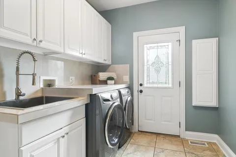 a utility room with sink dryer and washer