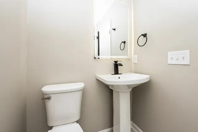 a bathroom with a sink a toilet and mirror