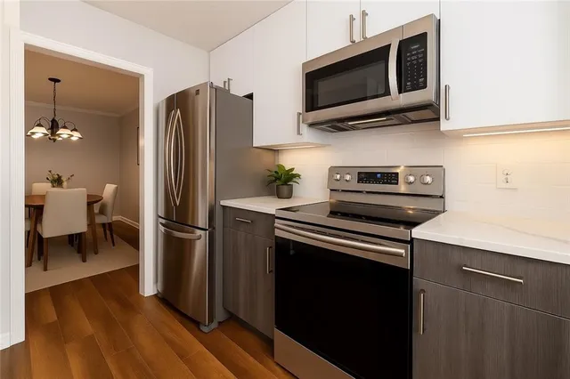 a kitchen with stainless steel appliances a refrigerator microwave and sink