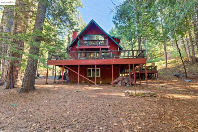 a view of large house with a big yard and large trees