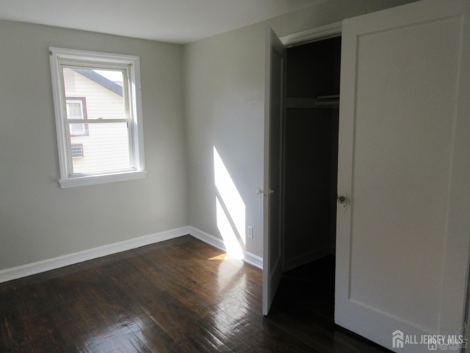 815 2nd Street, Unit B Dunellen, NJ 08812 - Photo 8 of 13 an empty room with wooden floor closet and windows