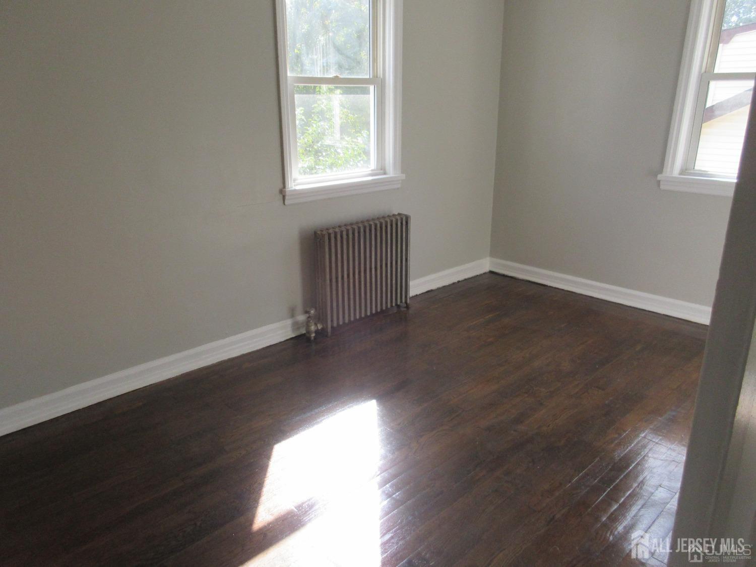 815 2nd Street, Unit B Dunellen, NJ 08812 - Photo 9 of 13 an empty room with wooden floor and windows
