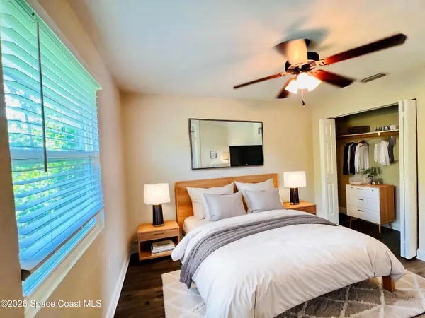 a bedroom with a large bed and a chandelier