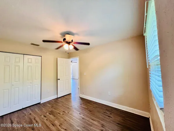 a view of a room with wooden floor and fan