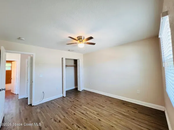 an empty room with wooden floor and window